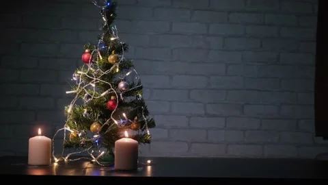 Christmas composition with burning candles and decorative fir tree in dark room. Video stock 166190567