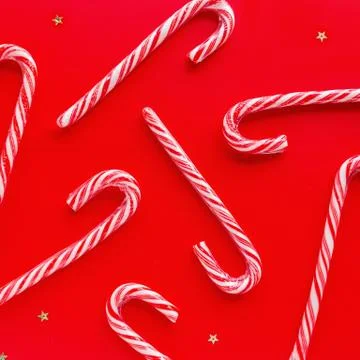 Christmas composition. Candy canes on red paper background. Minimal new year Stock-Fotos