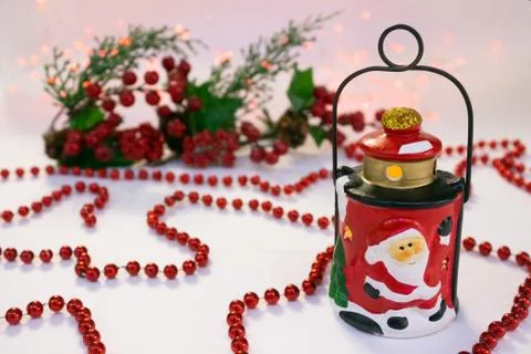 Christmas composition with ceramic lantern, red beads Stock Photos