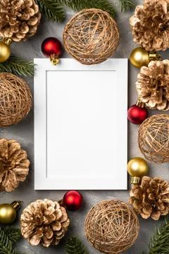 Christmas composition with empty picture frame. Golden ornament, pine cones Stock Photos
