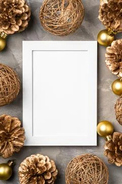 Christmas composition with empty picture frame. Golden ornament, pine cones Stock Photos