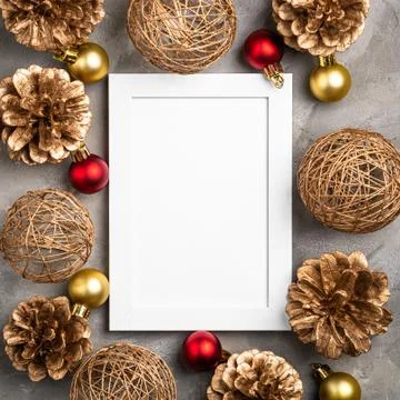 Christmas composition with empty picture frame. Golden ornament, pine cones Stock Photos