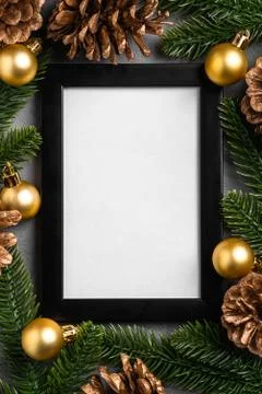 Christmas composition with empty picture frame. Golden ornament, pine cones Stock Photos