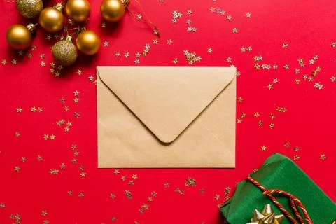 Christmas composition. Envelope, wrapped gift, toys on red background with go Stock-Fotos