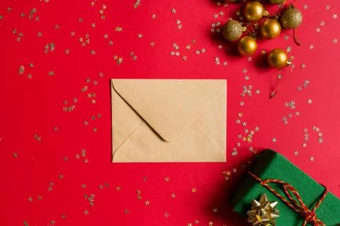Christmas composition. Envelope, wrapped gift, toys on red background with go Foto stock