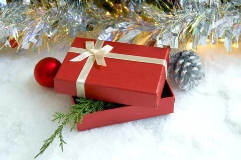 Christmas composition with fir tree branches, red gift box and silver tinse.. Stock Photos