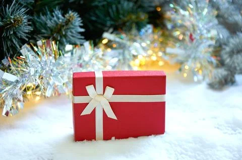 Christmas composition with fir tree branches, red gift box and silver tinse.. Stock Photos