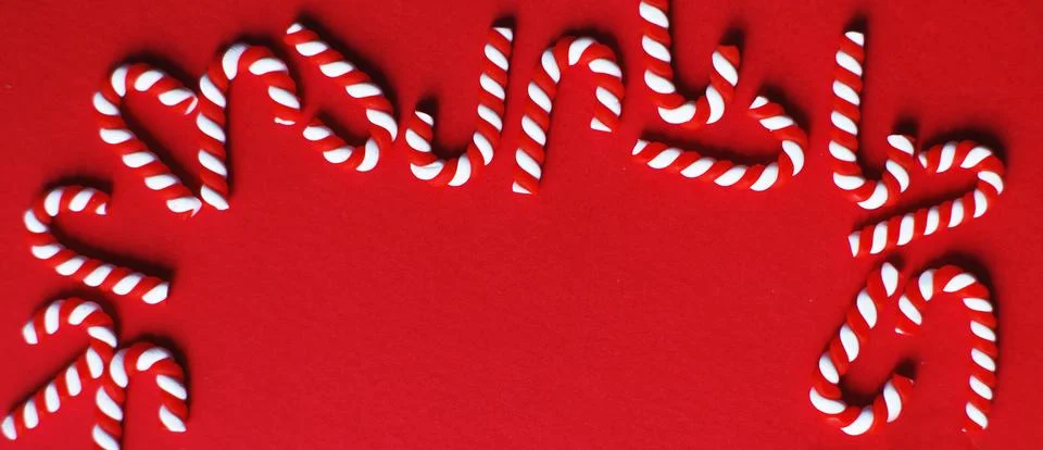Christmas composition with frame of candy canes on red background. Copy spa.. Stock Photos