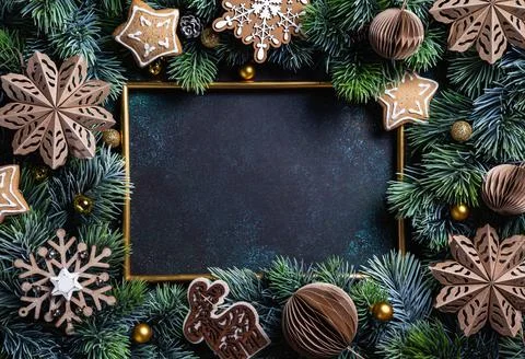 Christmas composition. Frame with gingerbread, pine branches, wooden and pape Фото