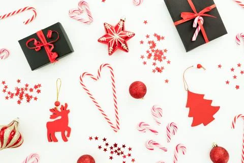 Christmas composition. Gift box, red decoration, candy canes and confetti on  Stock Photos