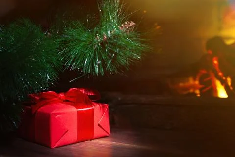 Christmas composition, gift under the tree near a burning fireplace, close-up Foto stock
