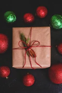 Christmas composition. Handmade gift box decorated with craft paper on dark b Stock Photos