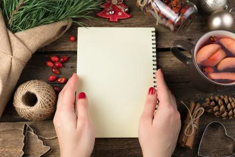 Christmas composition with a notebook in women's hands, fir branches and a Cup Foto stock