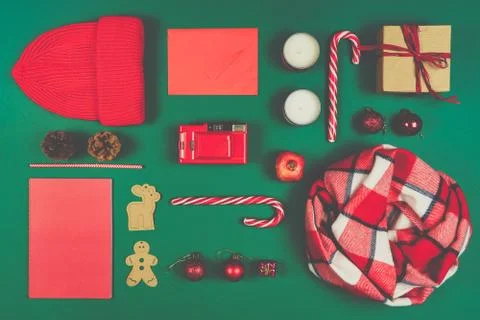 Christmas composition of objects in red color isolated on green background. Hat Stock Photos