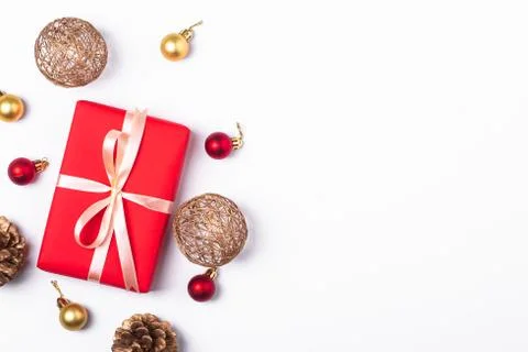 Christmas composition. Red gift box, pine cones, gold and red ornaments Stock Photos