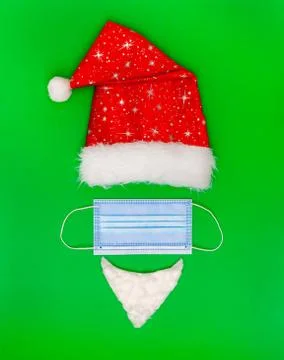 Christmas composition. Red hat, beard of Santa Claus, protective medical mask Stock Photos