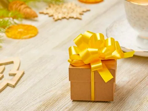 Christmas composition. Small gift box with lush yellow bow on a background of Stock Photos
