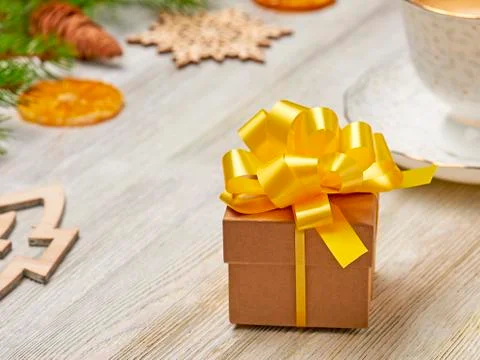 Christmas composition. Small gift box with lush yellow bow on a background of Stock Photos