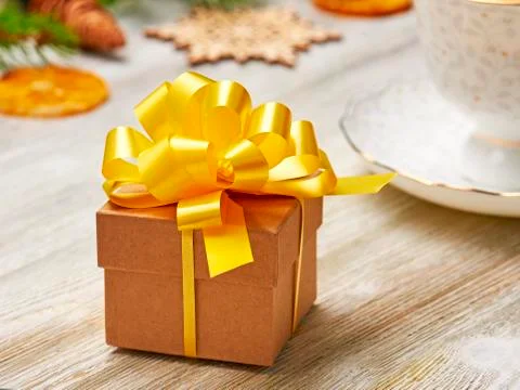 Christmas composition. Small gift box with lush yellow bow on a background of Stock Photos
