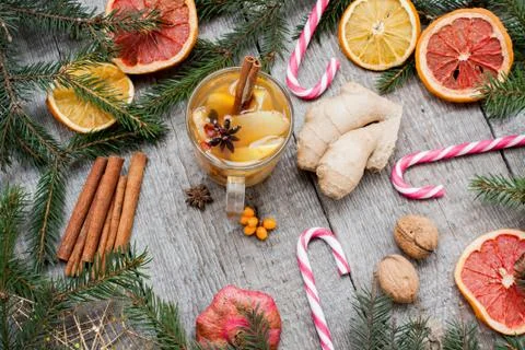 Christmas composition. Spruce branches, candy cane, warming tea Stock Photos