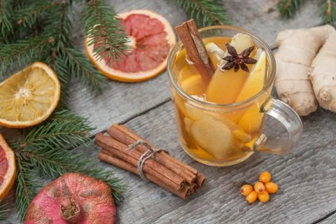 Christmas composition. Spruce branches, candy cane, warming tea Stock Photos