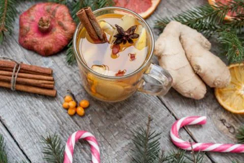 Christmas composition. Spruce branches, candy cane, warming tea Stock Photos