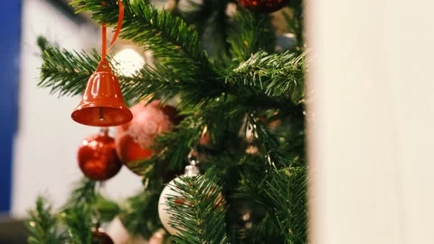 Christmas concept red bell slips sideways in slow motion in pine tree. Vídeo Stock 142768129