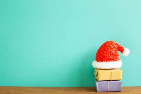 Christmas concept. Stack of gift boxes with santa claus hat on wooden table Stockfoto's