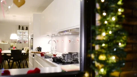 Christmas cooking in a kitchen while snow falls outside and woman prepares food Video stock 99724393
