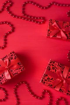 Christmas decor gift boxes bows beads red colors wooden background Stock Photos