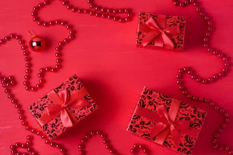 Christmas decor gift boxes bows beads red colors wooden background Stock Photos