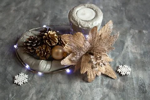 Christmas decor in silver-gold tones, an unusual flower, pine cones, candle Stock Photos