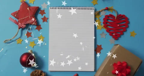 Christmas decorations on blue background with blank notepad and falling stars Stock Footage 305134068