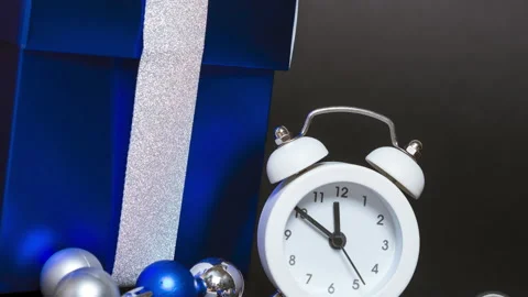 Christmas decorations. Composition with alarm clock, blue gift box and silver Stock Footage 159150491