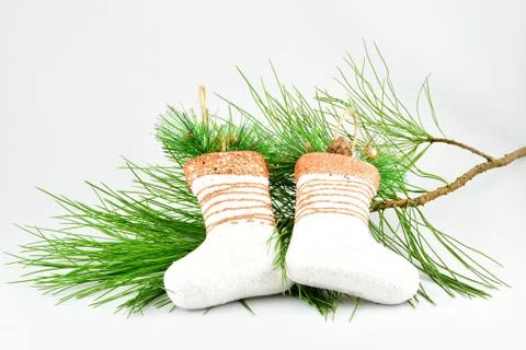 Christmas decorations, composition, white magic felt boots, green branch, pin Stock Photos