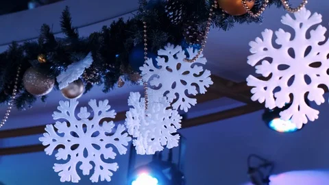 Christmas decorations in the form of snowflakes hang near a searchlight Stock Footage 122667553