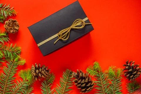 Christmas decorations layout or flatlay with fir branches and cones on red ba Stock Photos