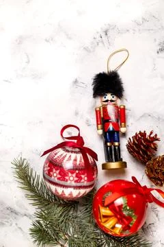 Christmas decorations. nutcracker, balls, pine cones on a textured background Stock Photos