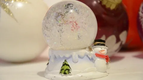 Christmas decorations. Snow falling in shiny magical crystal ball with snowman Stock Footage 70332639