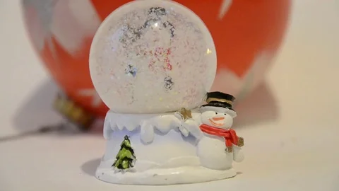 Christmas decorations. Snow falling in shiny magical crystal ball with snowman Stock Footage 70332780