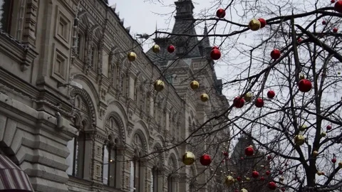 Christmas decorations swinging in the branches of a tree against the building Stock Footage 73076194