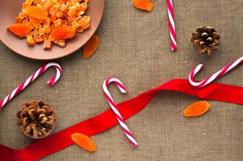Christmas decorations: top view of candy canes, cones and dried fruits on lin Stock Photos