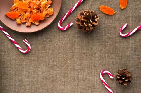 Christmas decorations: top view of candy canes, cones and dried fruits on lin Stock Photos