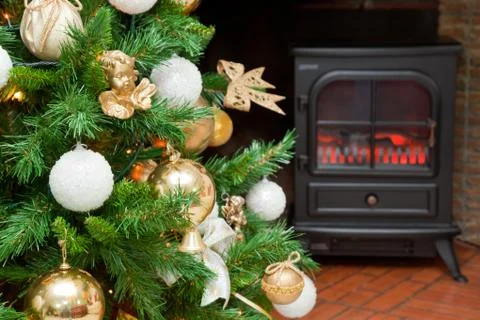 Christmas decorations on a tree with the bottom of a fireplace Stock Photos