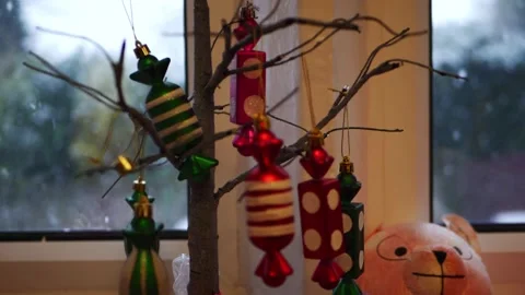 Christmas decorations on a tree as snow falls outside Stock Footage 166171365