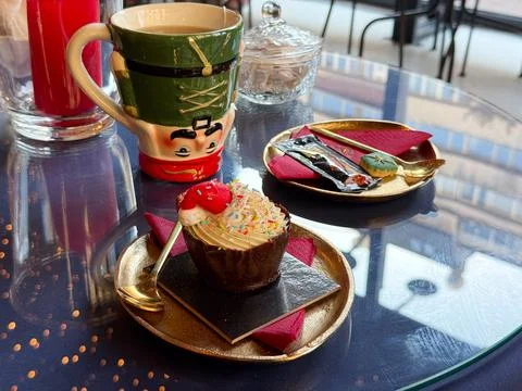 Christmas dessert setting with nutcracker mug and festive cupcake. Warm celeb Stock Photos