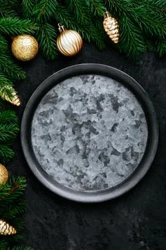 Christmas dinner background with empty plate and gold decor on dark table. Stock Photos