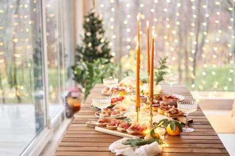Christmas dinner feast. A small table is served with snacks, bruschettas, and Stock Photos