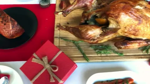Christmas dinner table concept of whole roast turkey on wooden cutting board Stock Footage 145606650