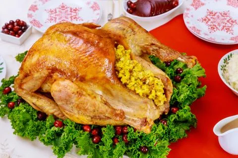 Christmas dinner table served with turkey, decorated with kale and cranberry. Stock Photos